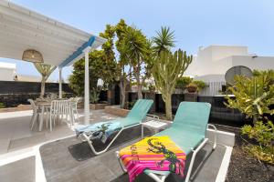 2 sillones y una mesa en el patio en Paraiso Marino by EscapeHome, en Los Pocillos