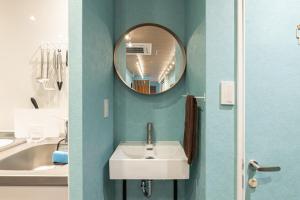 a bathroom with a sink and a mirror at TasoneUrbanStayOsaka 梅田北EFB2F in Wada +35 photos