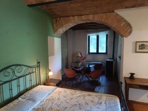 Un dormitorio con una cama y una mesa con sillas. en Cozy Country House, en LʼOpaco