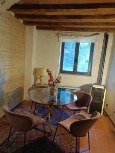 Una sala de estar con una mesa de cristal y sillas. en Cozy Country House, en LʼOpaco
