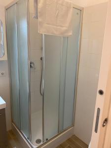 a bathroom with a shower with a white towel on it at Andrew House in Ciampino +13 photos
