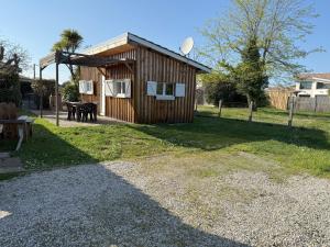 a small wooden building with a picnic table in a yard at Dépendance calme Gujan-Mestras in Gujan-Mestras