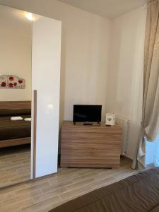 a living room with a television on a wooden dresser at Andrew House in Ciampino