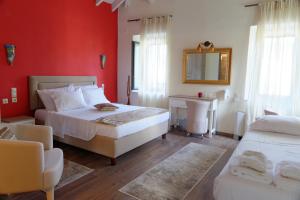 a bedroom with red walls and a bed and a mirror at Alexandra Hotel in Kaléntzion