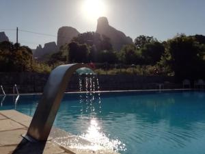 a fountain in a pool with mountains in the background at Farmhouse Meteora Garden in Kastraki