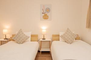 two twin beds in a room with two lamps at Mori hotel 十条401 in Tokyo