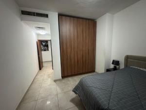 a bedroom with a bed and a wooden closet at Sloane House in Dzorwulu