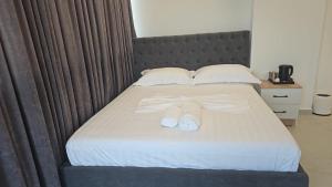 - un lit avec deux paires de chaussures blanches dans l'établissement Dashaj Rooms 304, à Ksamil