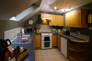 eine Küche mit gelben Schränken und einem weißen Herd mit Backofen in der Unterkunft Corrieview Lodges in Spean Bridge + 18 Fotos