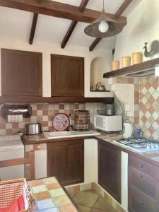 a kitchen with wooden cabinets and a stove top oven at Le gite lotus in Méounes-lès-Montrieux