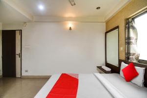 a bedroom with a large bed with red pillows at Hotel O New Tulip Santragachi Junction in Kolkata +28 photos