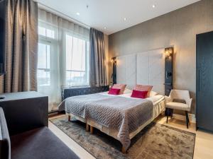 a bedroom with a large bed with pink pillows at Santa's Hotel Santa Claus in Rovaniemi