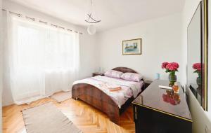 a bedroom with a bed and a table with flowers at Gardelin Apartment in Tivat