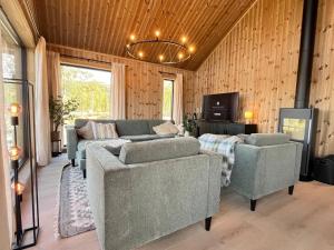 ein Wohnzimmer mit einer Couch und zwei Sesseln in der Unterkunft Skogsbu - Stylish, Close to Ski centers and hiking trails in Nystølen