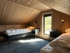 ein Schlafzimmer mit zwei Betten und einem Fenster in der Unterkunft Skogsbu - Stylish, Close to Ski centers and hiking trails in Nystølen