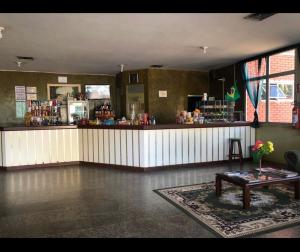 a bar with a counter and a table in a room at Transito Hotel in Araguaína