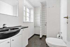 a bathroom with a black sink and a toilet at LD Central Lejlighed Odense C in Odense +6 photos