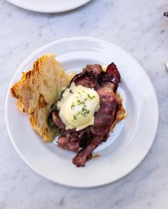 a plate of food with bacon and eggs on it at Cucu Hotel in Tel Aviv