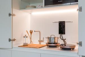a kitchen counter with a sink with a stove at Carlotta Apartments in Berlin