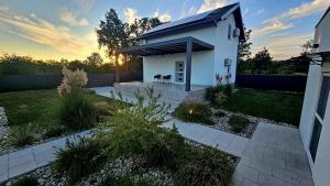 KorduševciCasa Cordis的一座白色的小房子,在庭院里设有一个庭院