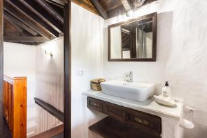 a bathroom with a white sink and a mirror at Casa Rural El Naranjero in Tanque +45 photos