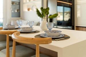 Una mesa de comedor con platos y vasos encima. en Luxury Modern Apartment with Stunning Glyfada View, en Atenas 40 fotos más
