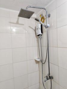 a shower with a shower head in a bathroom at 7F Cozy 2BR Condo - Central Location in Lapasan +11 photos