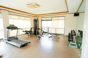 a gym with several exercise equipment in a room at 7F Cozy 2BR Condo - Central Location in Lapasan