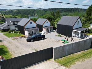 un coche aparcado delante de una hilera de casas en Domki Cypel Zawóz, en Zawóz