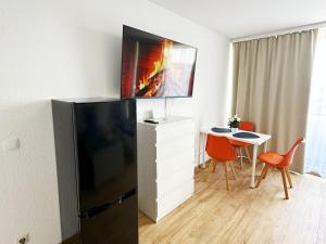 Una sala de estar con un refrigerador negro y una mesa. en Bright Modern Apartment in Mülheim an der Ruhr, en Mülheim an der Ruhr