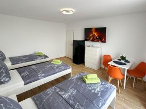 una habitación con dos camas y una mesa y un escritorio en Bright Modern Apartment in Mülheim an der Ruhr, en Mülheim an der Ruhr