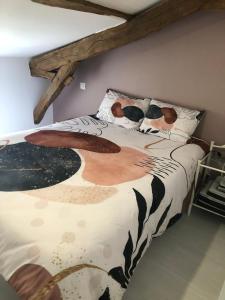 a bedroom with a bed with a comforter on it at Nature, Tourisme et Tranquillité in Saint-Fort-sur-Gironde +4 photos