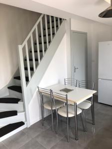 a dining room with a table and chairs and a staircase at Nature, Tourisme et Tranquillité in Saint-Fort-sur-Gironde