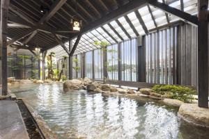 a pool of water with rocks in a building at TAOYA Nachikatsuura in Nachikatsuura