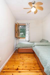 una camera da letto con due letti singoli e un ventilatore a soffitto di Esencia Pirineos l BQQ l Pisicina l Tenis a Biescas Altre 22 foto
