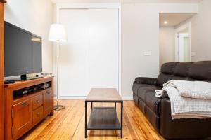 a living room with a couch and a tv at Esencia Pirineos l BQQ l Pisicina l Tenis in Biescas +19 photos