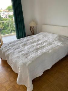 a white bed in a bedroom with a window at NICE BAIE DES ANGES in Nice +23 photos