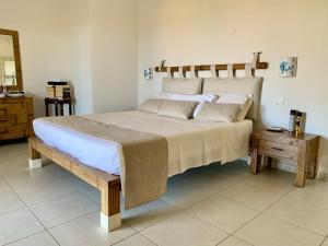 a bedroom with a large bed with a wooden headboard at Villa Starlight vista mare La Caletta in Santa Lucia