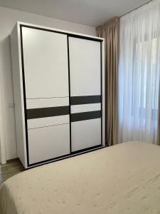 a bedroom with a large white and black closet at Harmony Apartments Airport in Iaşi +6 photos