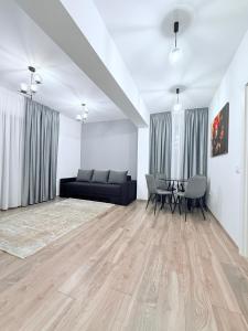 a living room with a couch and a table at Harmony Apartments Airport in Iaşi