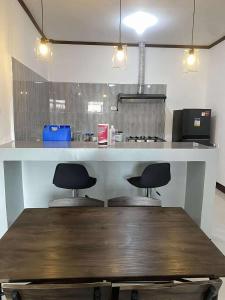 a kitchen with two stools under a counter at Cozy Home in Malaybalay 2 Bedrooms and 1 Bathroom in Malaybalay