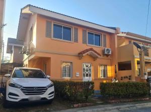 Un coche blanco aparcado delante de una casa en Feel At Home, Stay At Home, en Batangas