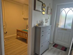 a room with a white cabinet and a window and a door at Aafiyat House in Aldershot