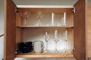 ein Schrank mit darin stehenden Weingläsern in der Unterkunft Stylish Tiny Cabin Pitrog in Pitragutsiyeme