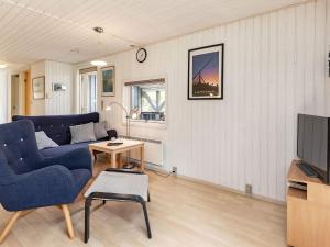 a living room with a blue couch and a tv at 5 person holiday home in Ålbæk-By Traum in Ålbæk +34 photos