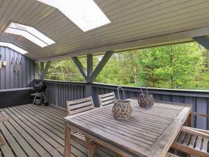 a wooden table and chairs on a wooden deck at 5 person holiday home in Ålbæk-By Traum in Ålbæk