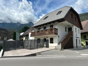 a white building with a balcony and a fence at APARTMA ALMA in Bovec