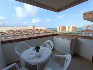 a white table and chairs on a balcony with a view at ACV - Torremar-2ª linea planta 8 norte in El Borseral +24 photos