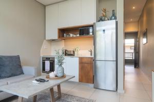 a kitchen with a stainless steel refrigerator and a table at Zimbali Suites 617 in Ballito