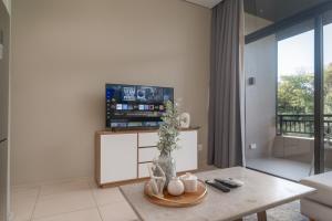 a living room with a table and a tv at Zimbali Suites 617 in Ballito